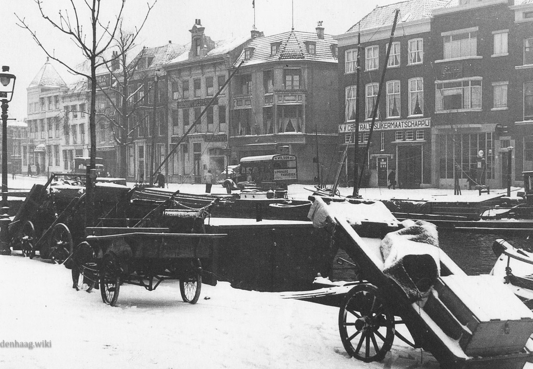 De Bierkade in 1938 kijkend richting de Wagenstraat. De straat naast de Centrale Suikermaatschappij is de Kranestraat. Hier stond in het verleden de kraan die het bier uit de schepen tilde. Op de voorgrond  het Groenewegje.